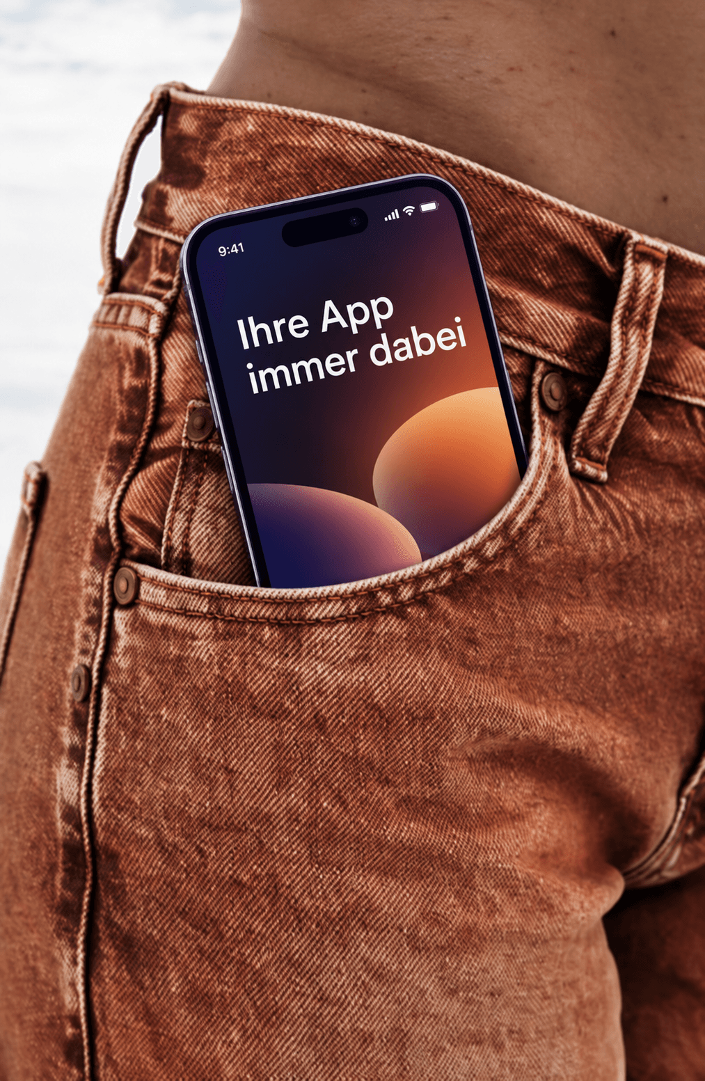 Beispiel-Creative für App-Kampagnen: Smartphone in einer Jeanstasche mit dem Schriftzug „Ihre App immer dabei“