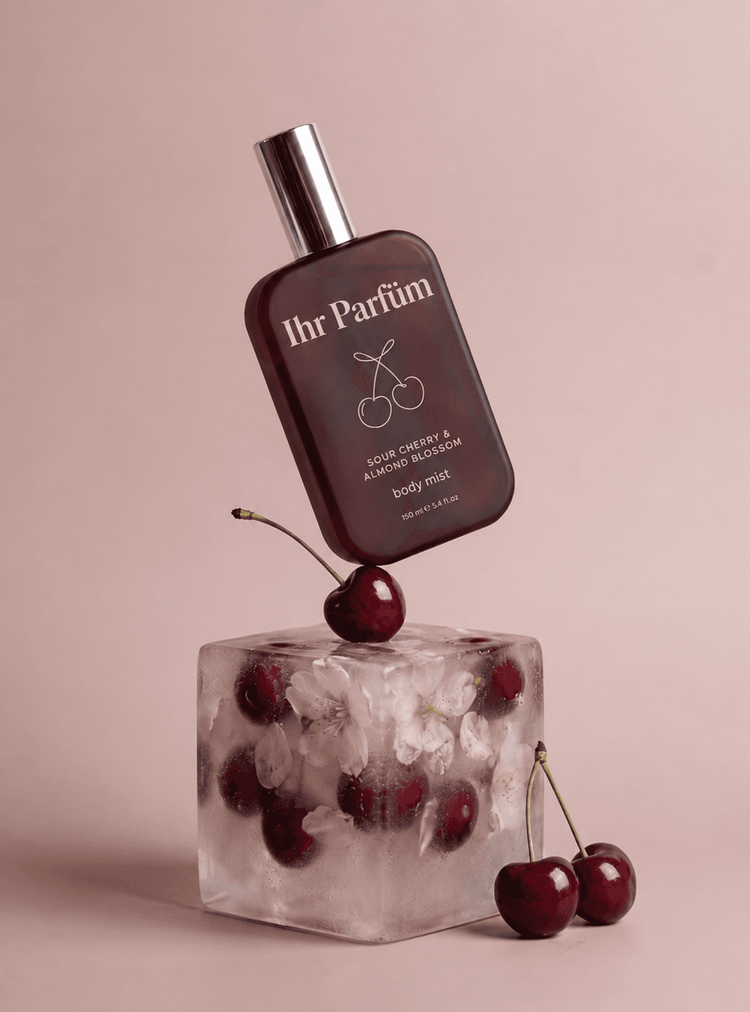 Beispiel-Creative für Meta Ads: Flakon „Ihr Parfüm“ Body Mist auf einem Eisblock mit Kirschen und Kirschblüten – Produktinszenierung für Instagram und Facebook