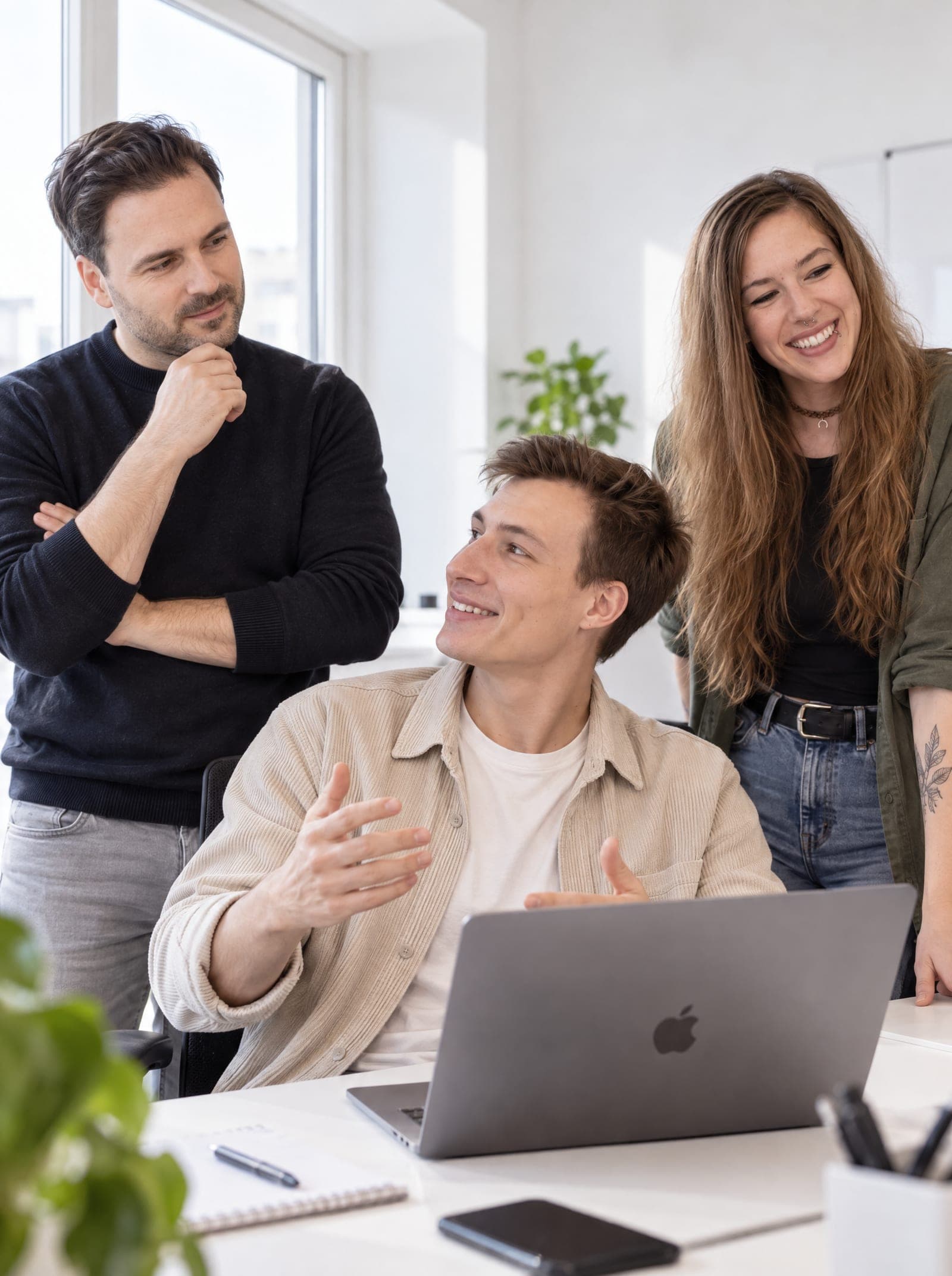 Drei Mitglieder des ClickScale-Teams besprechen am Laptop eine Kampagne im Büro in Dresden