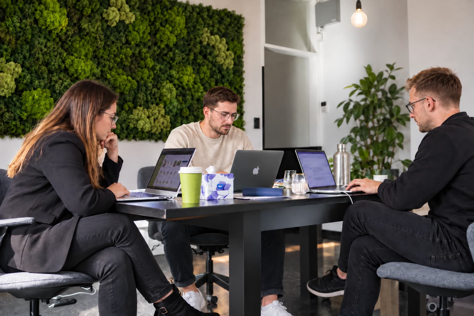 Das ClickScale-Team bei der Kampagnenarbeit im Büro in Dresden – drei Personen mit Laptops am Besprechungstisch